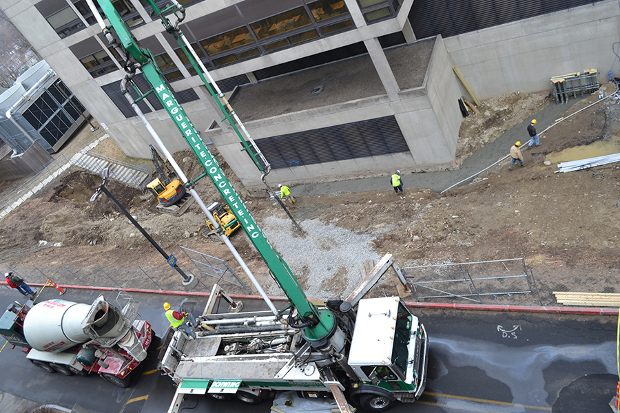 Workers pour concrete at the  base of the third floor hill