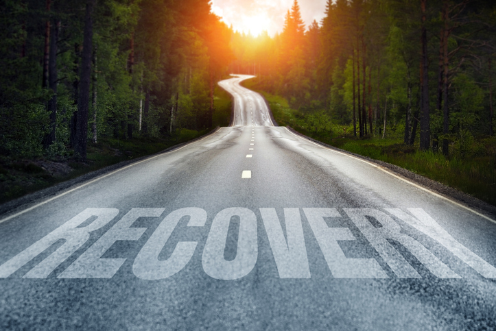 A road leading off into the distance with the word "Recovery" running across it