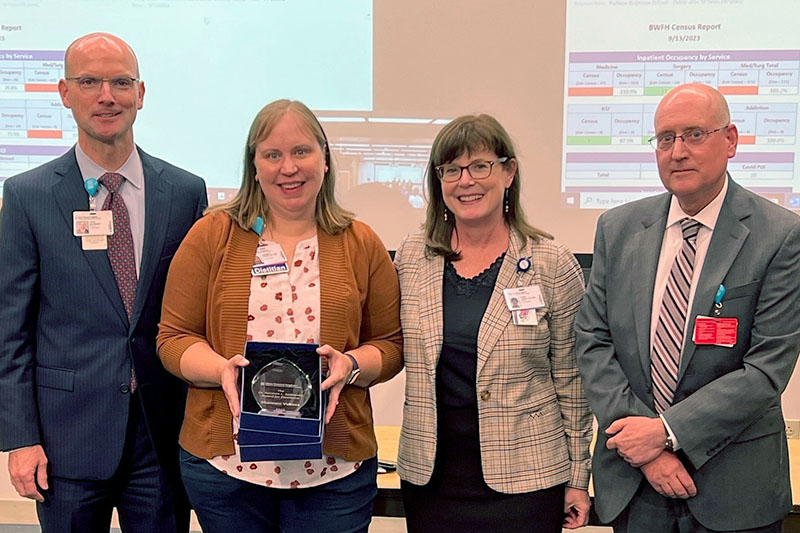 Award winner Shannon Vukosa holding her award next to three colleagues