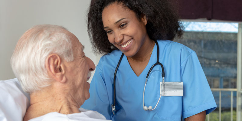 female nurse tending to older male patient