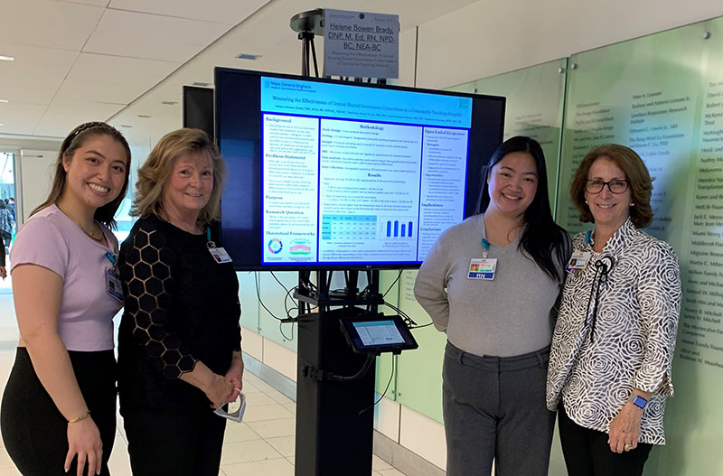 Jaceline Fianza, Kathleen Ahern Gould, Cassandra Ramsey and Helene Bowen Brady standing with poster