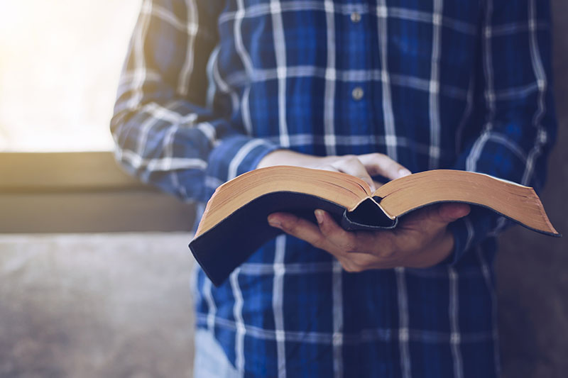 Person reading a religious book.