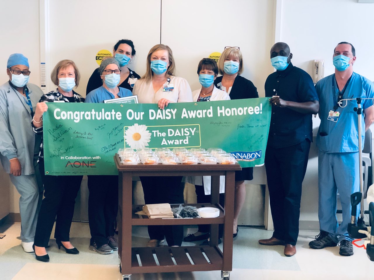 Photo of Mary Deseignora receiving a DAISY award from her colleagues